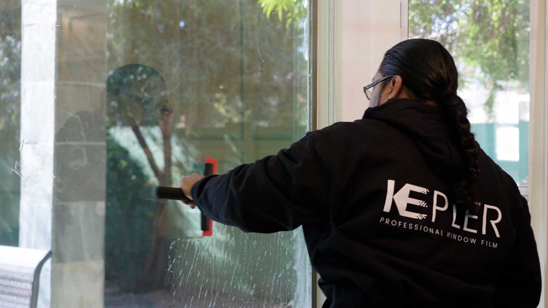Kepler Installer Applying Security Window Film to a Building in Massachusetts