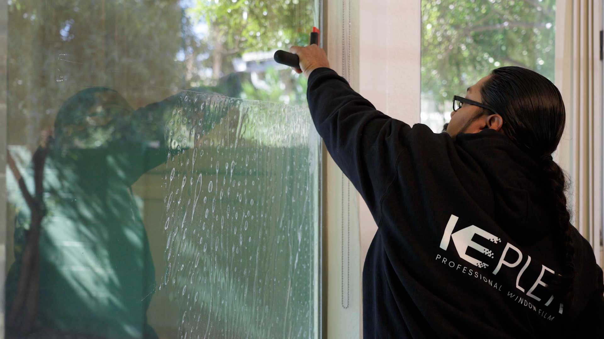 Kepler Installer Applying Security Window Film to a Building in Alabama