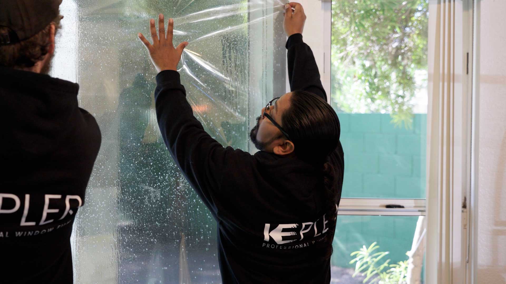 Kepler Installer Applying Security Window Film to a Building in Michigan