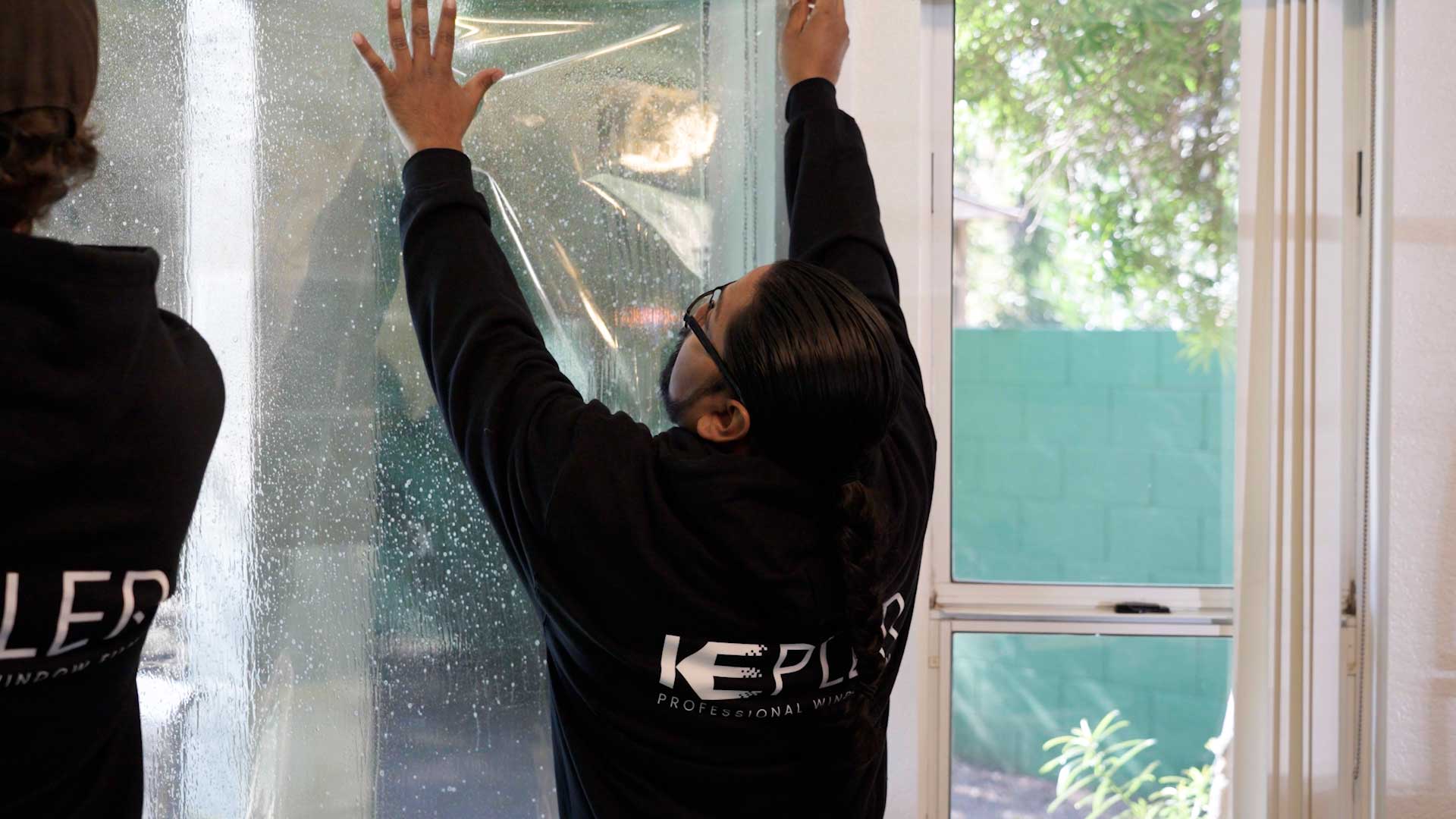 Kepler Installer Applying Security Window Film to a Building in Minnesota