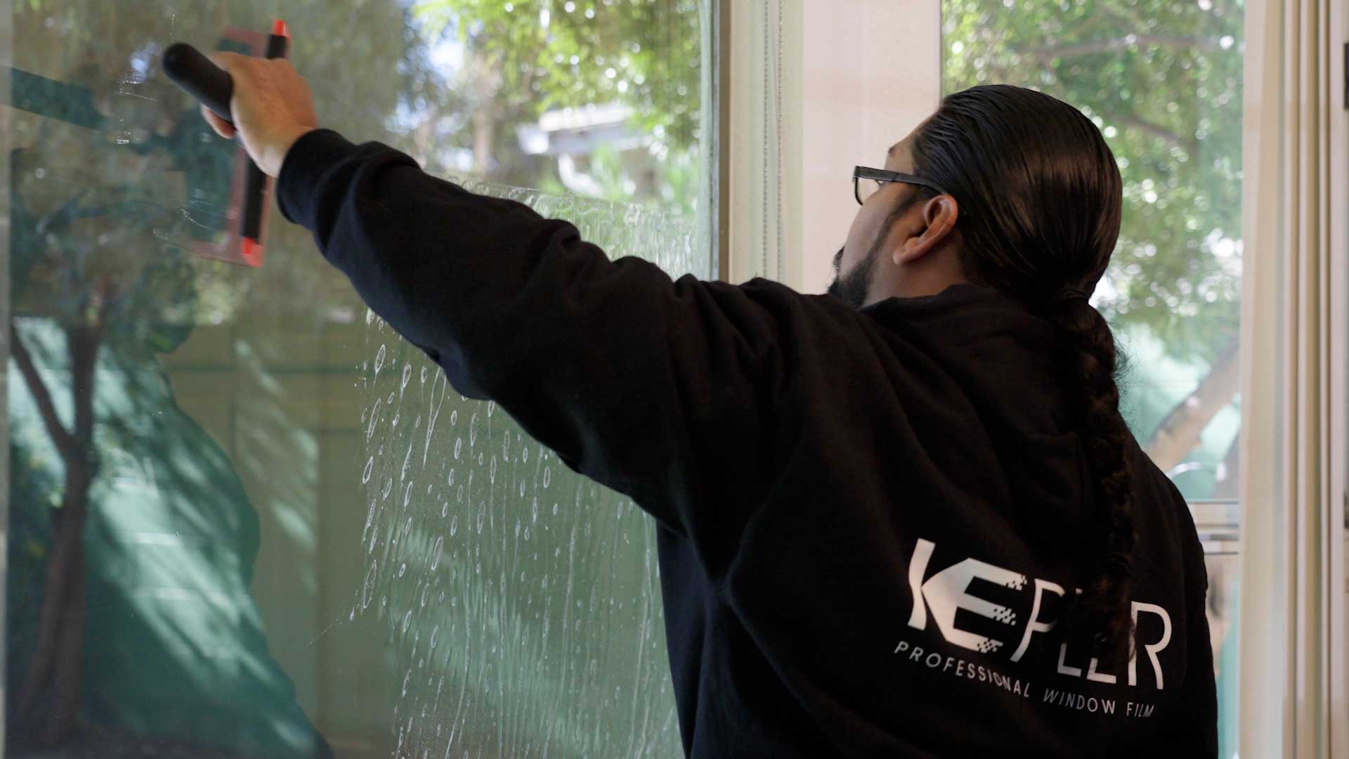 Kepler Installer Applying Security Window Film to a Building in Alaska